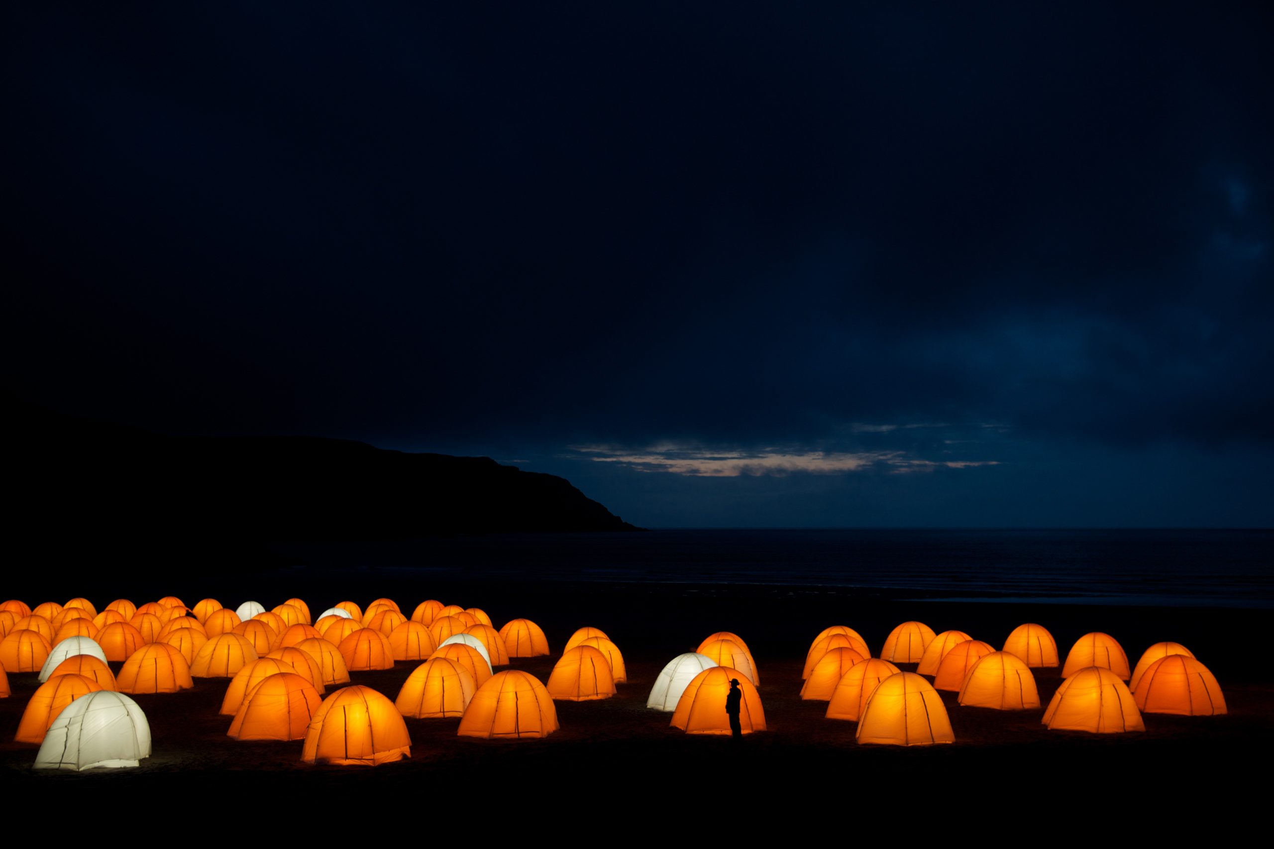 Peace Camp at Cliff Beach, Valtos, Isle of Lewis at night, silhouette of a person in front of one of the tents