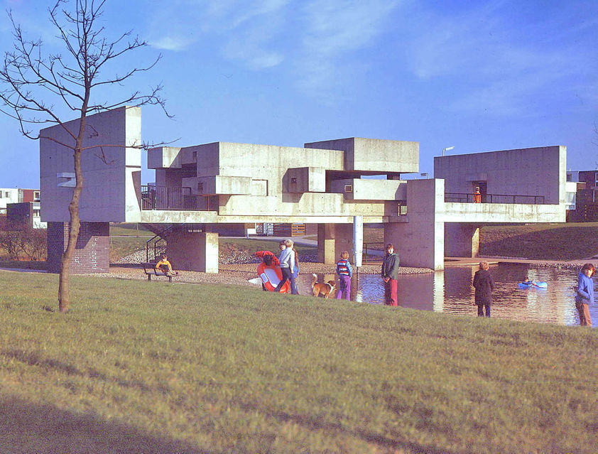 Geometric structure on a sunny day, surrounded by gathering of people.