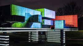 Apollo Pavilion illuminated in striped monochrome light at the bottom and block red, blue and green light on the top.