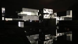 Apollo pavilion lit up with a black and white striped projection