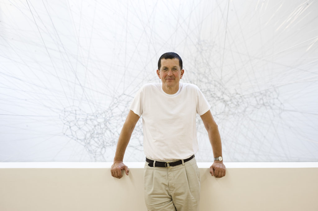 Landscape image of Antony Gormley against white backdrop