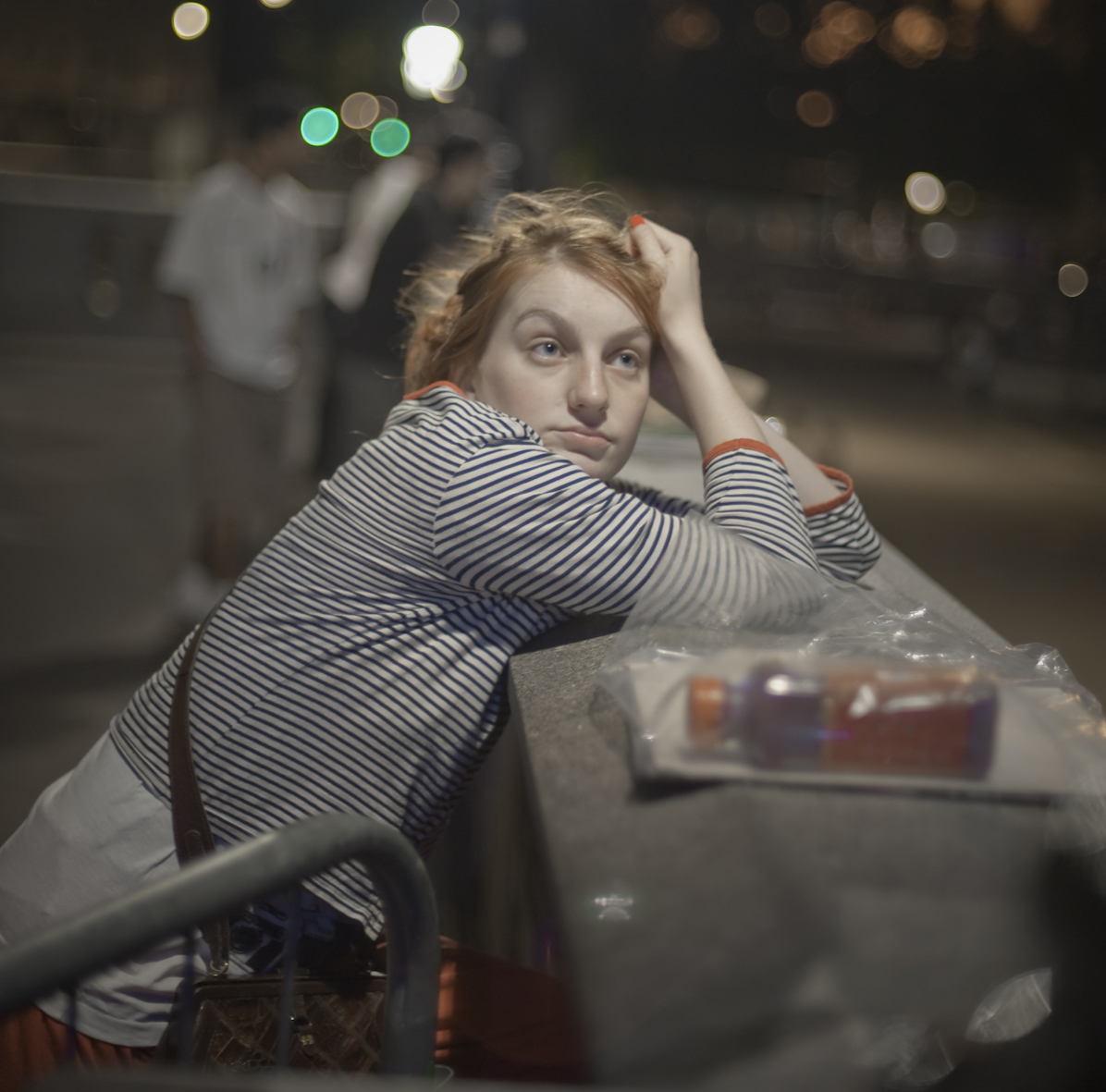 Woman leaning on a wall looking up at the plinth