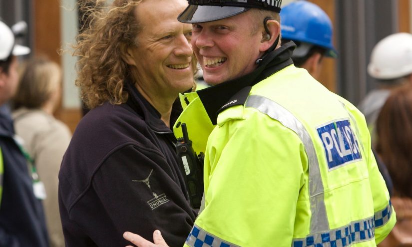 Alan Jacobi, La Machine, Liverpool, 2008. Photo by Matthew Andrews Police man smiling in the foreground and Alan Jacobi standing behind smiling.