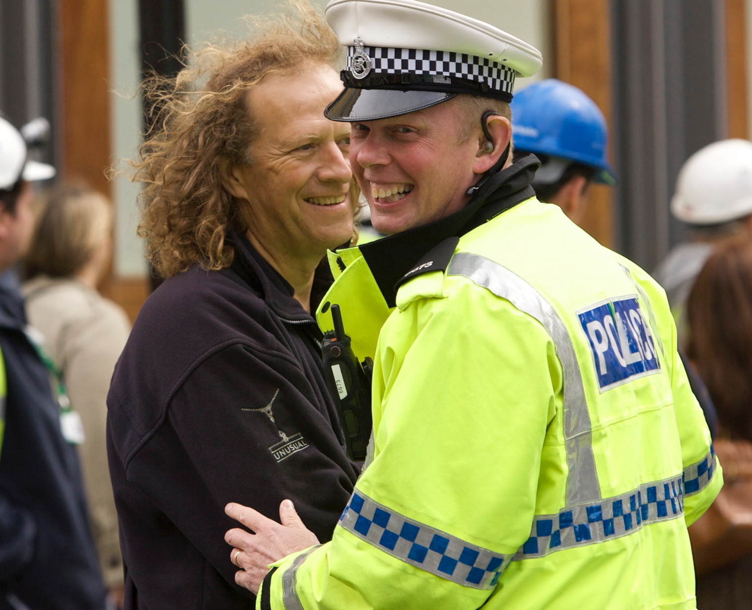 Police man smiling in the foreground and Alan Jacobi standing behind smiling.