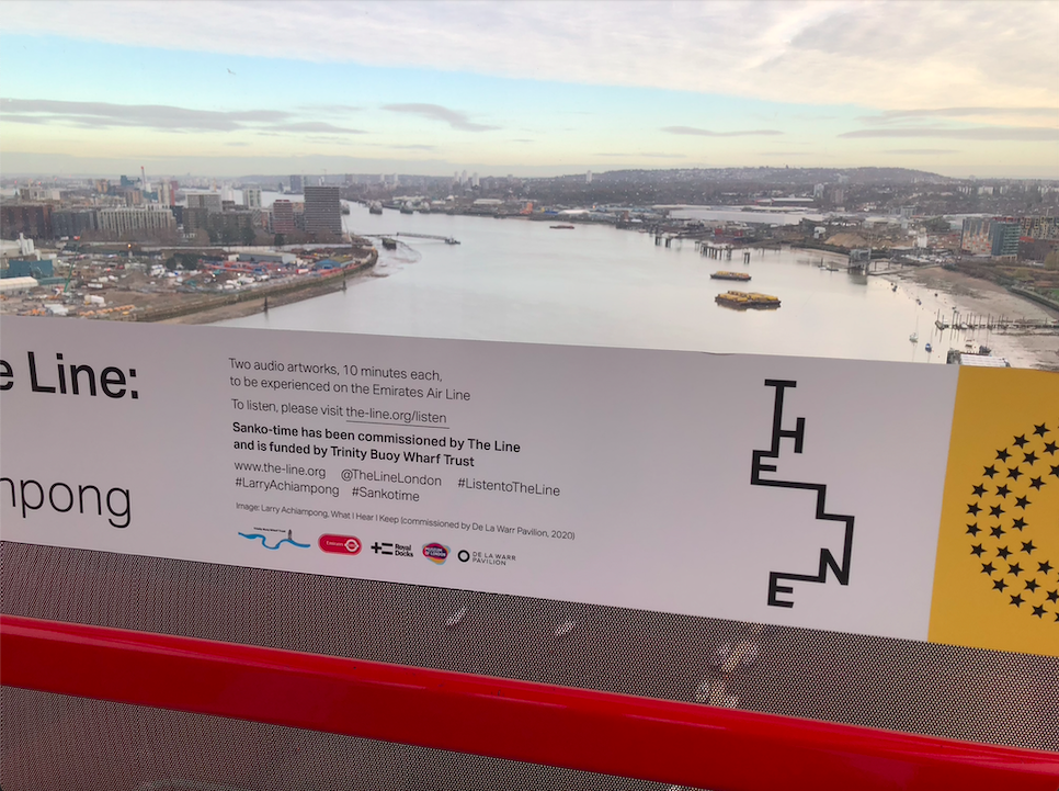 View of the river thames from the emirates sky line. Inside the carriageway is a sign which reads 