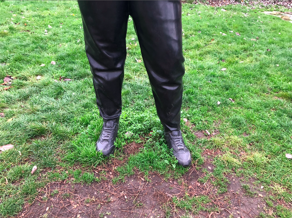 Close up shot of the feet of the bronze sculpture, the woman's trainers are placed directly on the grass