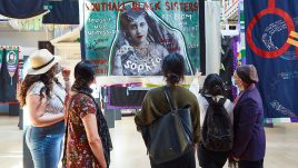 Southall Black Sisters looking at their banner at the Women Making History exhibition