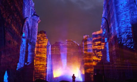 A projection of blue and orange lighting and fog at Finchale Priory in Durham