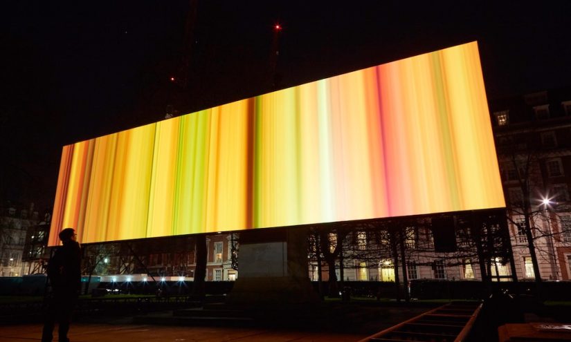 Spinning Night in Living Colour, Elaine Buckholtz (US). Lumiere London 2016, produced by Artichoke, supported by Mayor of London. Photograph © Matthew Andrews 2016 Billboard with warm yellow and red horizontal lines across it