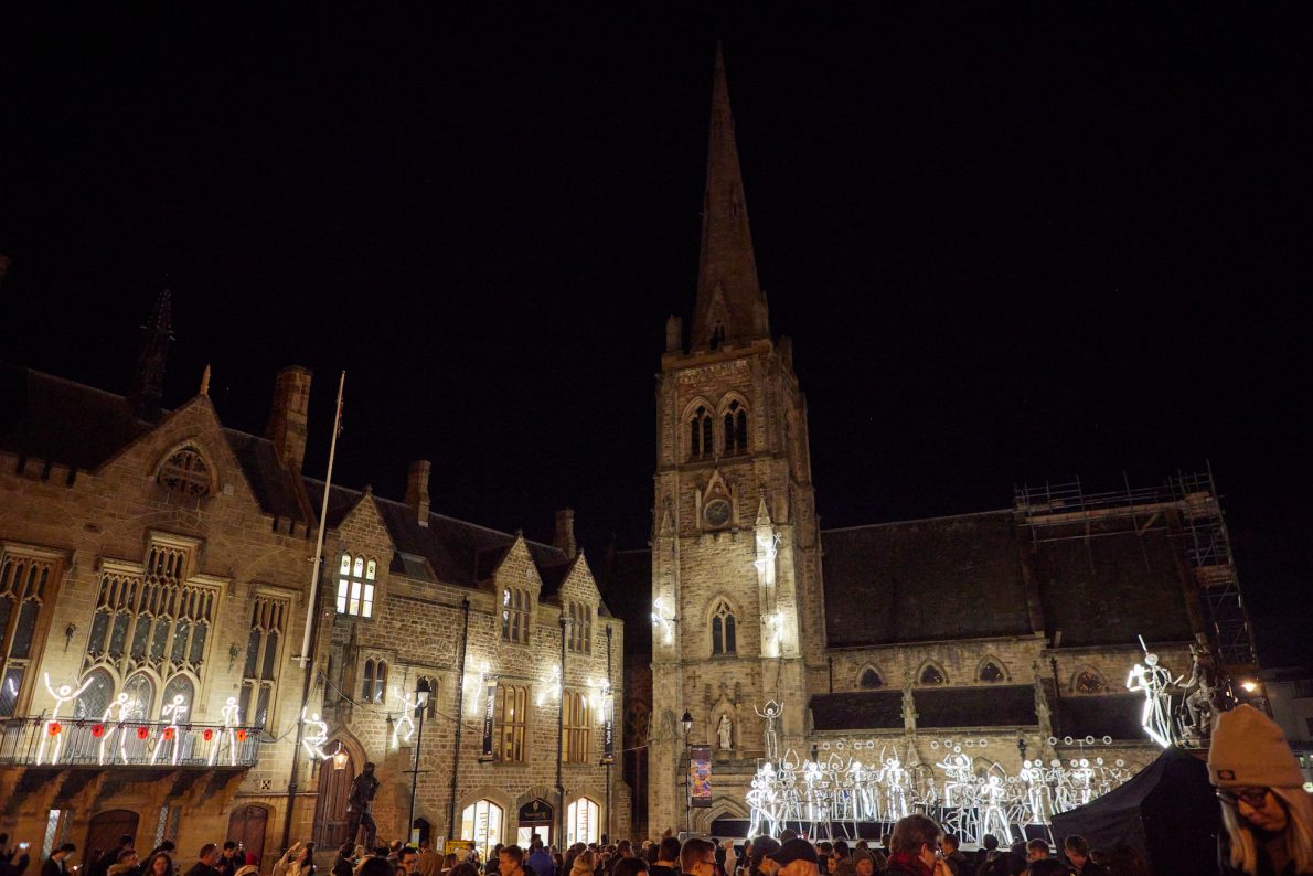 A band of stick men in front of Durham town hall