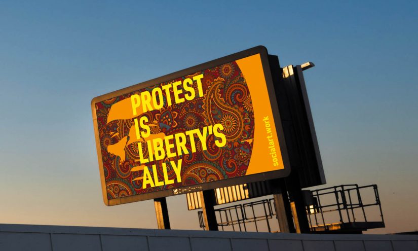 Billboard against a blue sky. Text reads: Protest is liberty's ally.