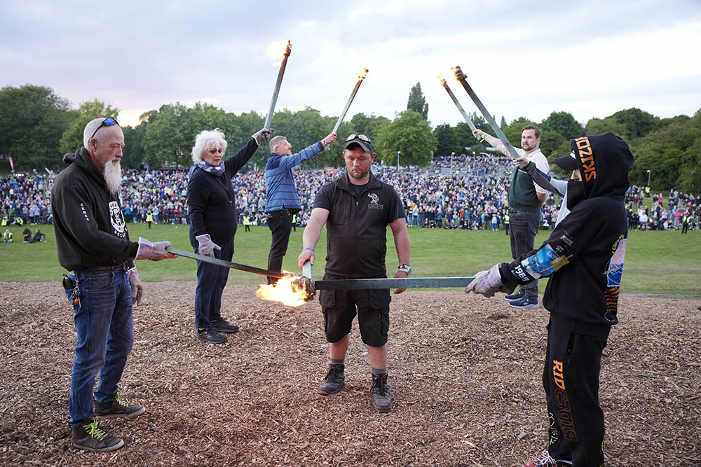 Seven torch bearers holding torches at the top of the hill in the Miners' Welfare Park