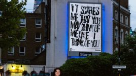 Photo of art by Anya Naumovic on a billboard; Black and white hand printed letters spelling 