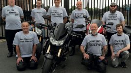 Art by Shiro Masuyama; a group of bikers around a motorcycle. The each wear a different tshirt with words they have chosen that they feel best describe them