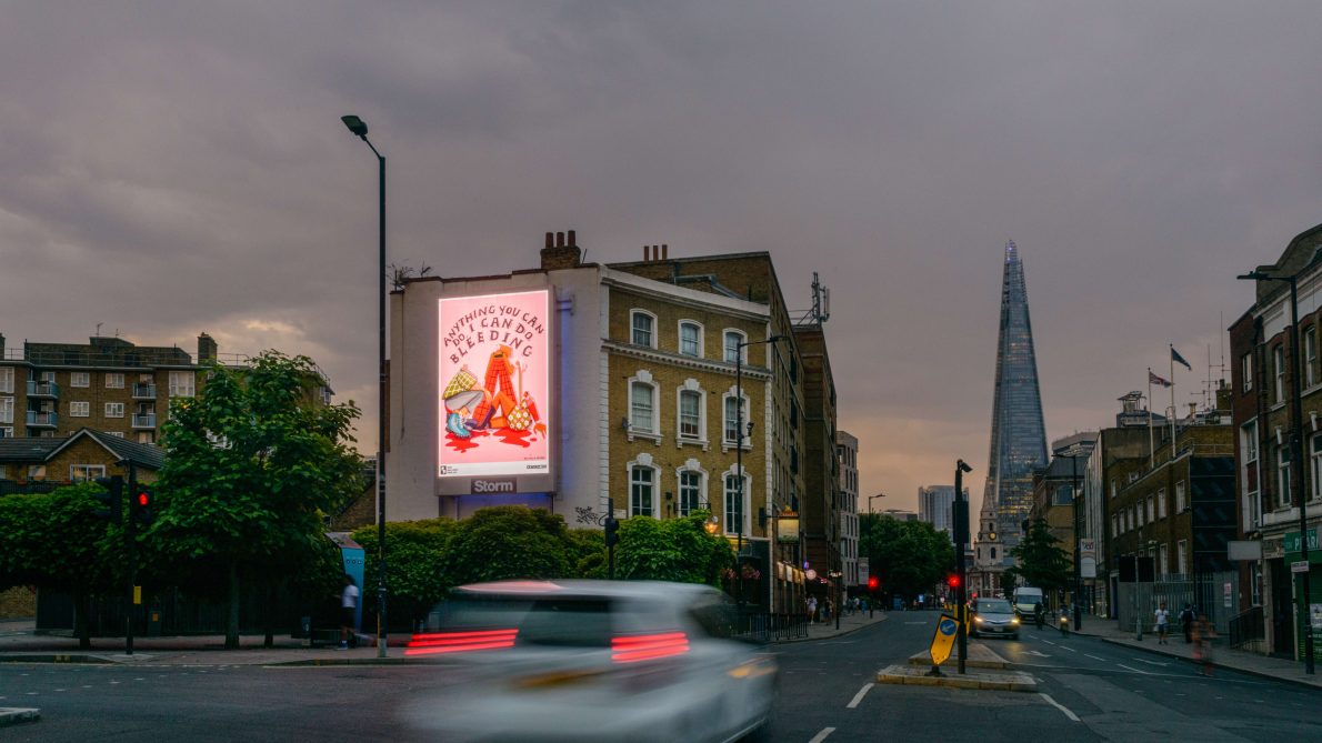 Nichola Irvine's artwork displayed on a digital screen on Borough High Street in London. The artwork shows three people sitting and standing on a pool of blood. Text reads: Anything you can do, I can do bleeding