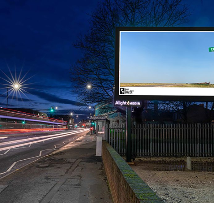 A billboard of CRY (2022) by Allyson Packer overlooking a busy road at night. A barren landscape. A freight train can barely be seen in the distance. A road sign in the foreground reads 'CR Y'.
