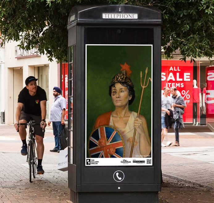 A phone box screen on a street displaying ‘Rue The Waves’ (2022) by Natasha Klutch. A painted portrait of a regal looking woman in patriotic British colours. She is holding a bent trident, a round Union Jack shield and a helmet with a lion on it. She has a black eye and is covered in tomato juice.