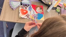 A workshop in Belfast for Season 2 of The Gallery. A young person is sat using art supplies. They are creating collages in repsonse to the theme 