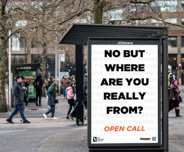 A bus shelter screen displaying the words: NO BUT WHERE ARE YOU REALLY FROM? OPEN CALL.
