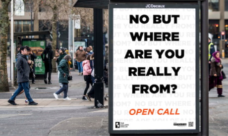 A bus shelter screen displaying the words: NO BUT WHERE ARE YOU REALLY FROM? OPEN CALL.