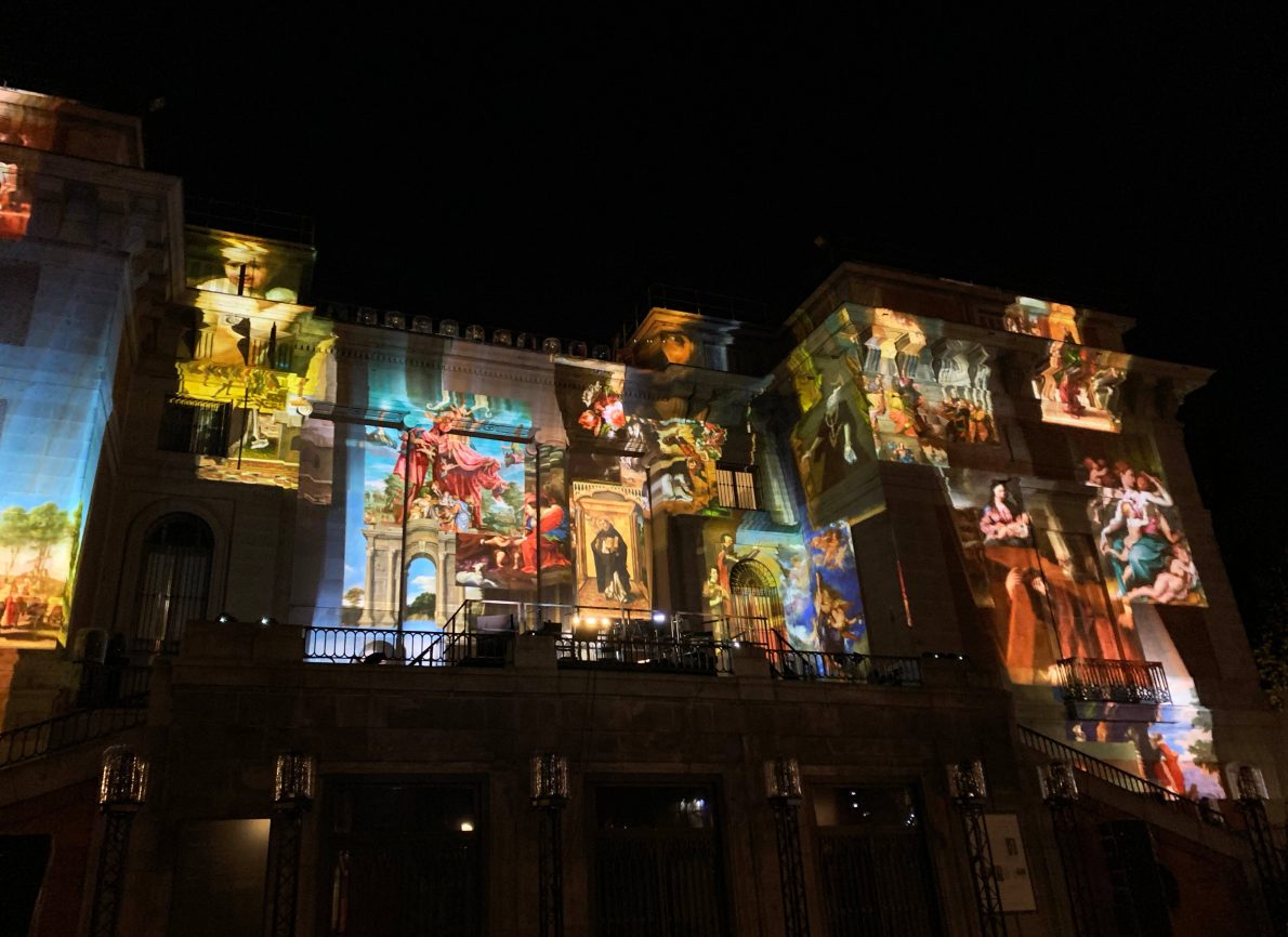 The façade of a building with projections of iconic Spanish paintings melting down the building.