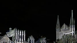 The artwork 'Liquid Geometry' by Javier Riera. Durham Cathedral at night. The building is cloaked by geometric, black and white projections.