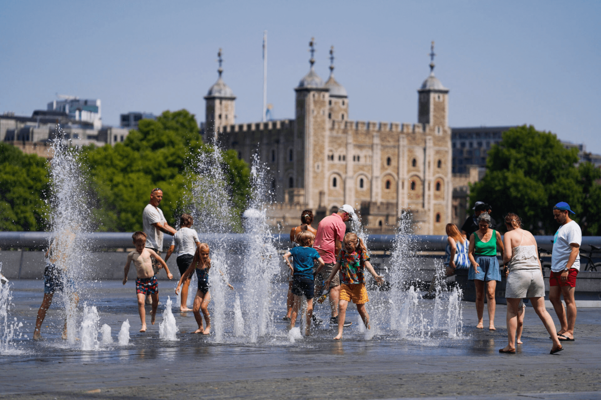 People cool off in the water fountains by Tower Bridge during a heatwave in London 2022