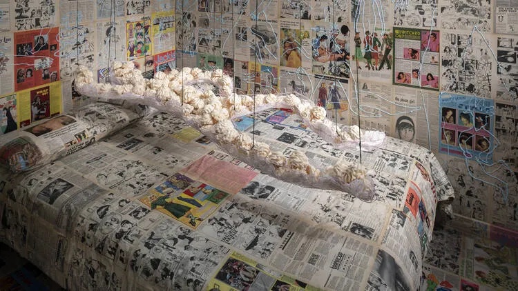Daughter figure made of meringues and walls plastered with 1970s magazines and newspapers for An Edible Family in a Mobile Home at Tate Britain as part of Women in Revolt! in 2023.